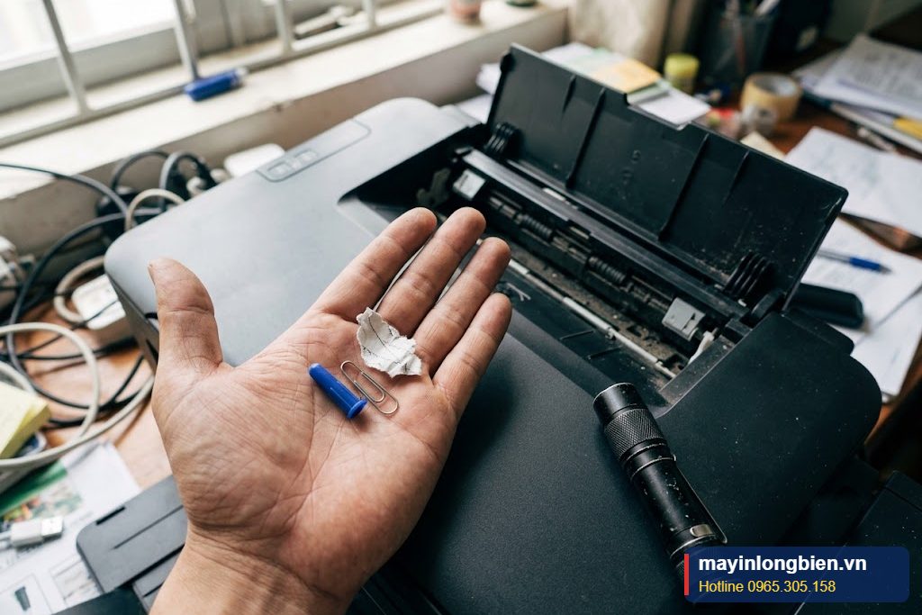 Cận cảnh nắp bút và kẹp ghim lấy ra từ khay sau máy in Canon bị kẹt giấy