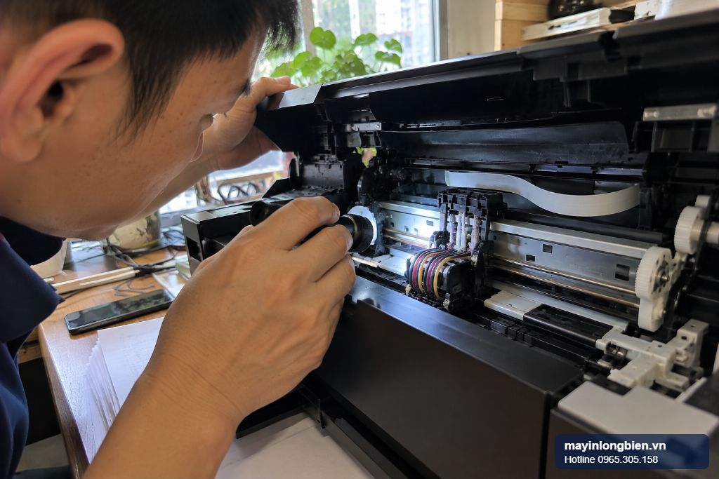 Kỹ thuật viên soi đèn đường chạy cụm đầu in khi xử lý lỗi 5100 máy in Canon