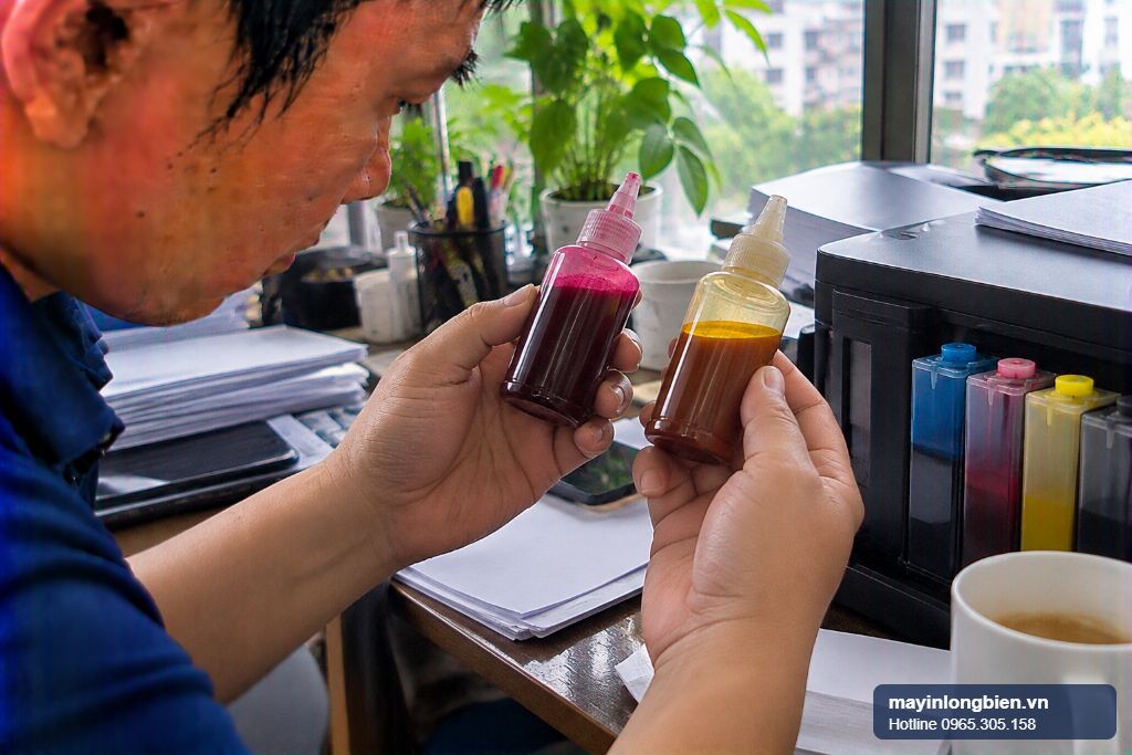 Bình mực pigment và dye trên máy in Epson đặt cạnh nhau để so sánh trước khi đổi mực
