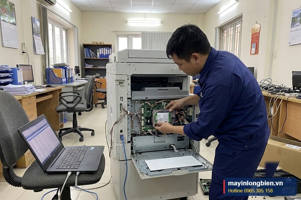 Kỹ thuật viên lắp ổ cứng mới và cài lại phần mềm hệ thống cho máy photocopy