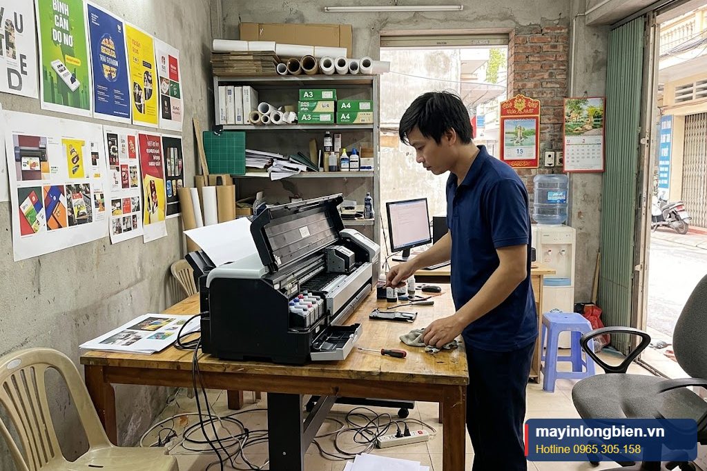 Kỹ thuật viên Thần Vũ kiểm tra đường giấy máy in màu khổ A3 tại văn phòng khách